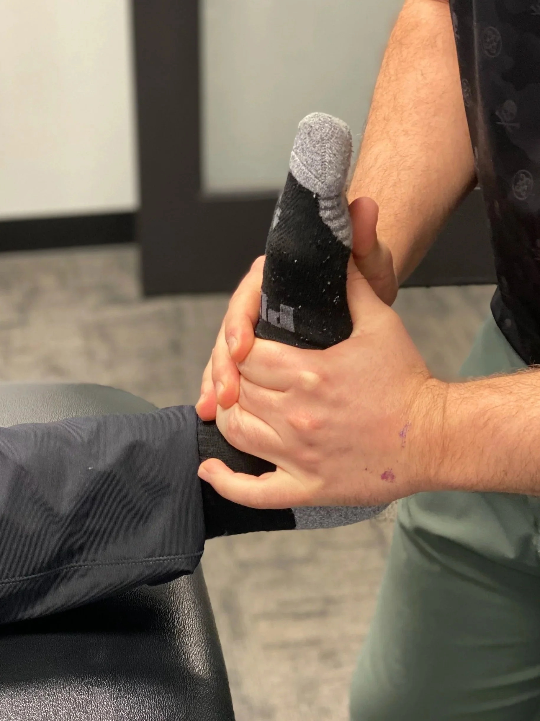 Physical rehabilitation, Chiropractor performing ankle dorsiflexion mobility treatment to improve ankle movement and reduce knee stress at Radius Physical + Sports Rehab in Nevada City.