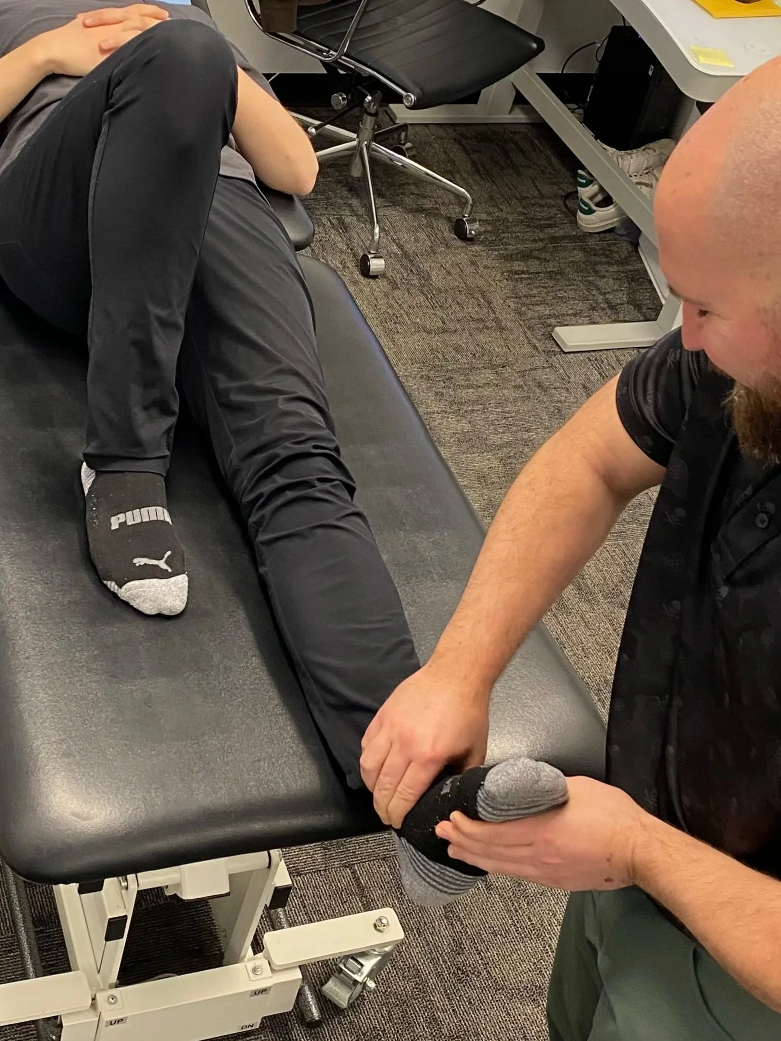 Chiropractor providing hands-on ankle joint mobilization and manual therapy to improve mobility and reduce lower extremity pain at Radius Physical + Sports Rehab in Nevada City.