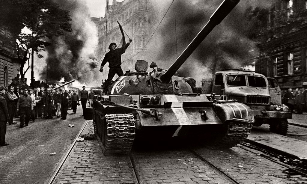 A Soviet Soldier stands on a tank, invading Prague.