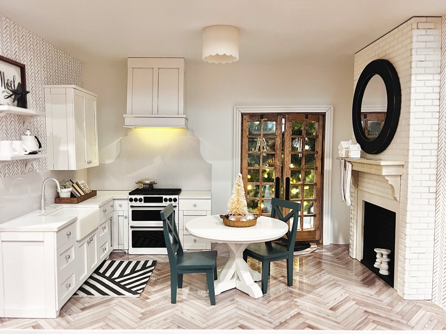 Imagine whisking up holiday magic in this pint-sized kitchen. A round trestle table takes center stage, stockings hang by the fireplace nearby and herringbone hardwood floors weave it all together. 🏡 🍽️✨ #MiniHomeJoy