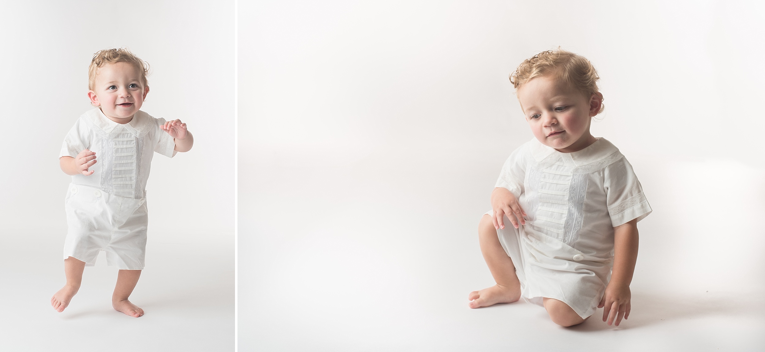 One year old boy in white heirloom outfit takes wobbly steps on a bright white background