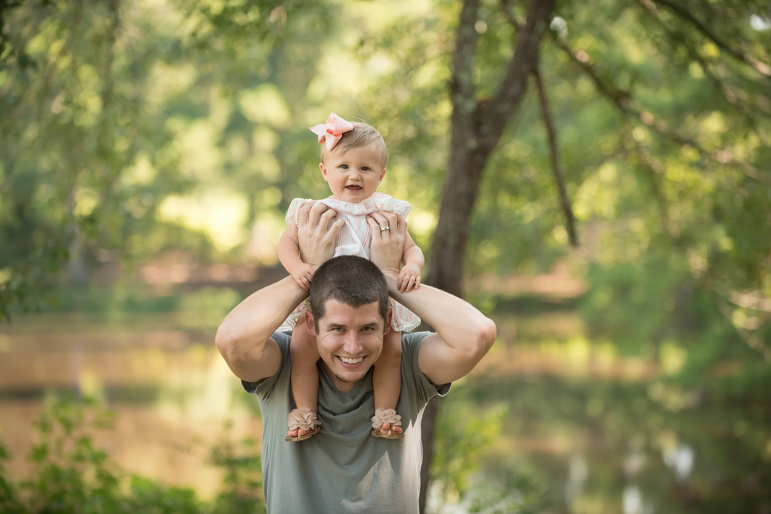toddler girl rides on her dad's shoulders