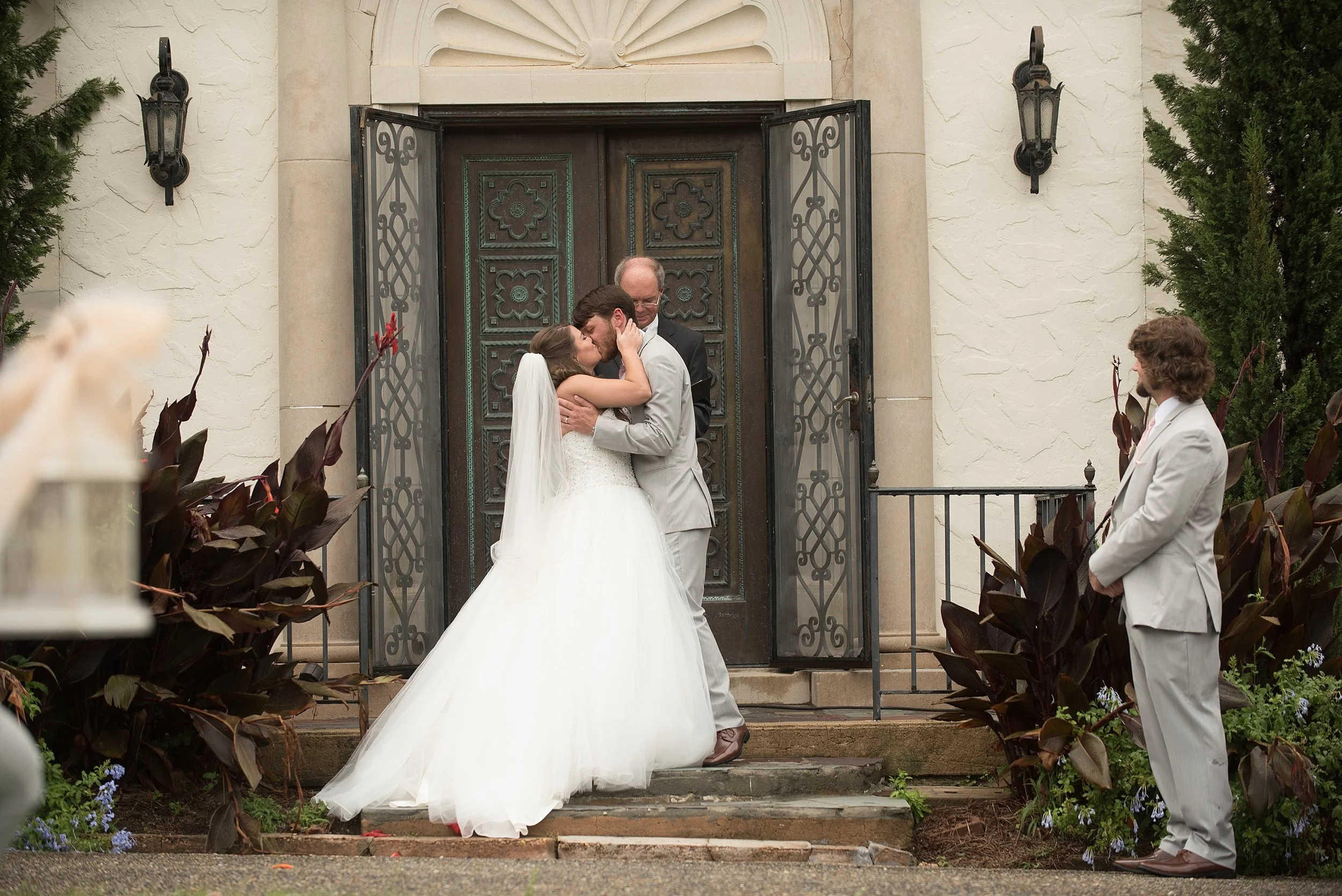Bride and groom have their first kiss as husband and wife during their wedding ceremony at Springdale in Andalusia, Alabama