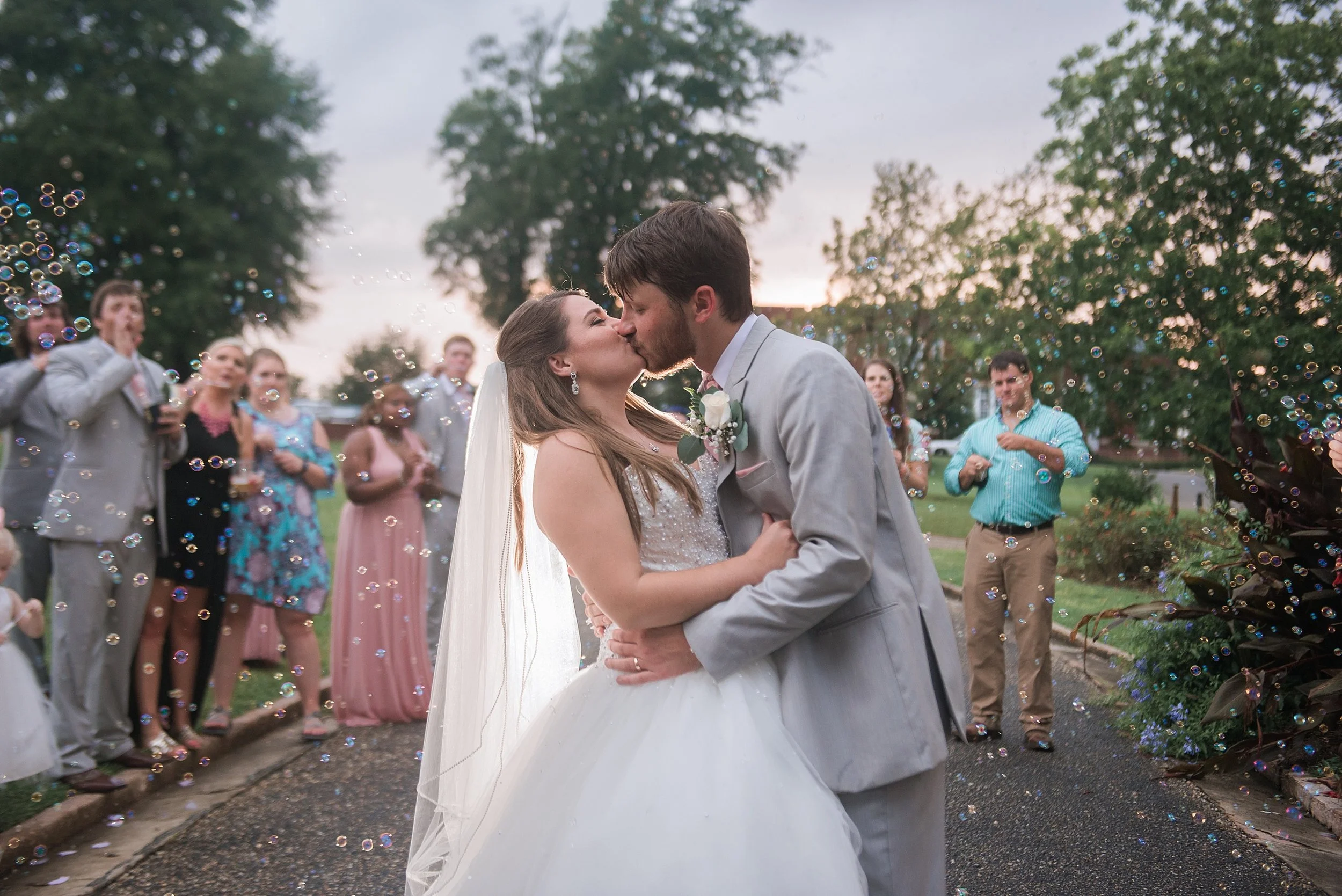 bride and groom kiss during their bubble wedding exit