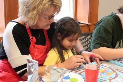 Learn-to-Paint-class-at-The-Grand-Center-for-Arts-and-Culture-Rhonda-assisting-young-artist.jpg