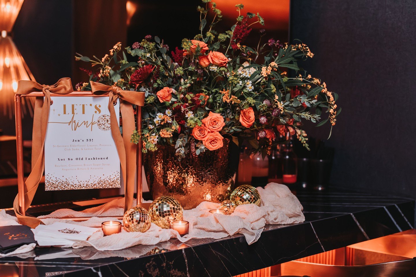 It really was a vibe. You can practically feel it through these photos &mdash; don&rsquo;t you think? ✨
For Jen&rsquo;s 55th, the vision was intimate, cozy, simplistic but elegant, and built around rich copper and gold fall tones. One little gold dis