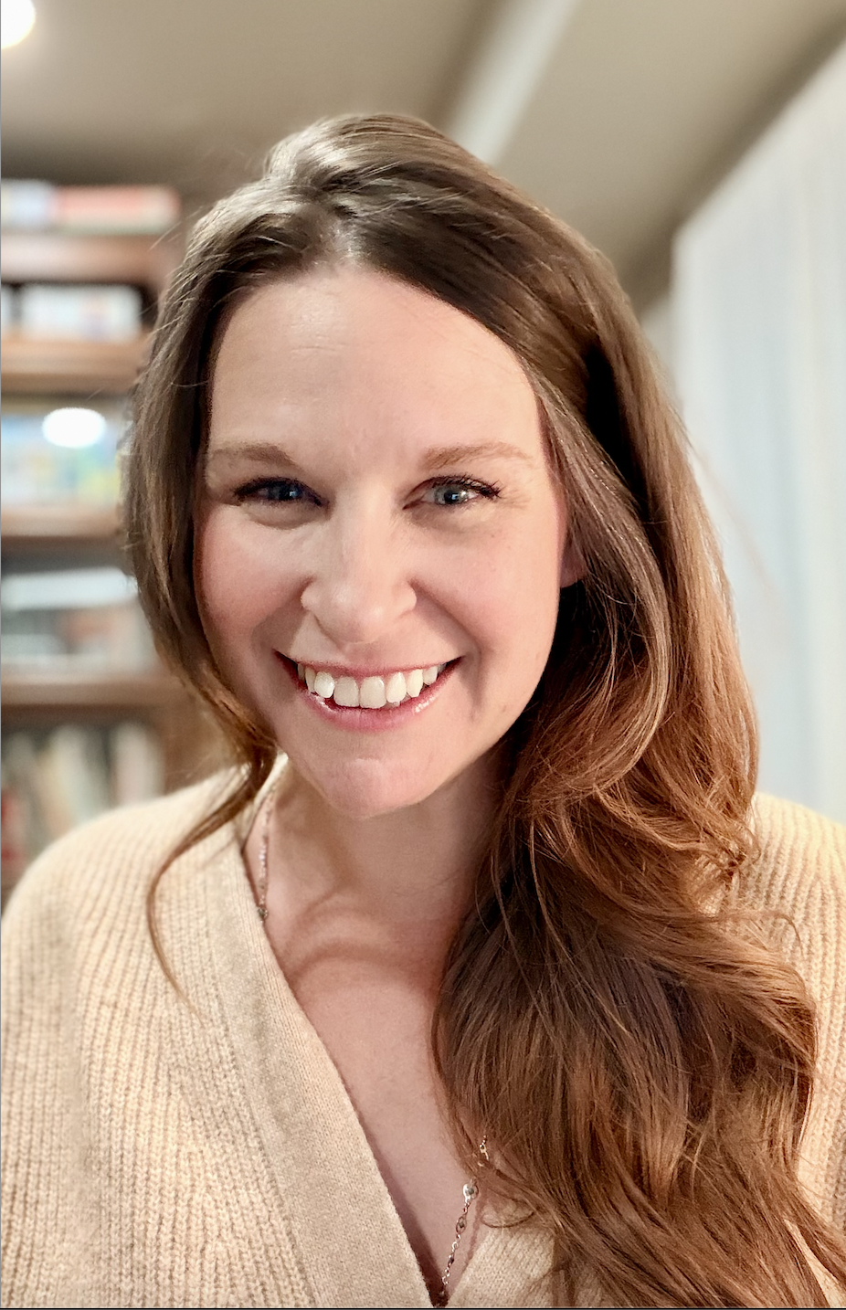 Rebecca Payne, relational therapist, with long brown hair wearing a beige sweater indoors.