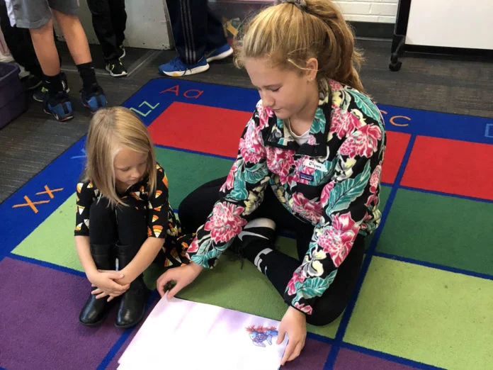 Ellyana Teliczan helps her Grandville kindergarten partner read through the book she chose