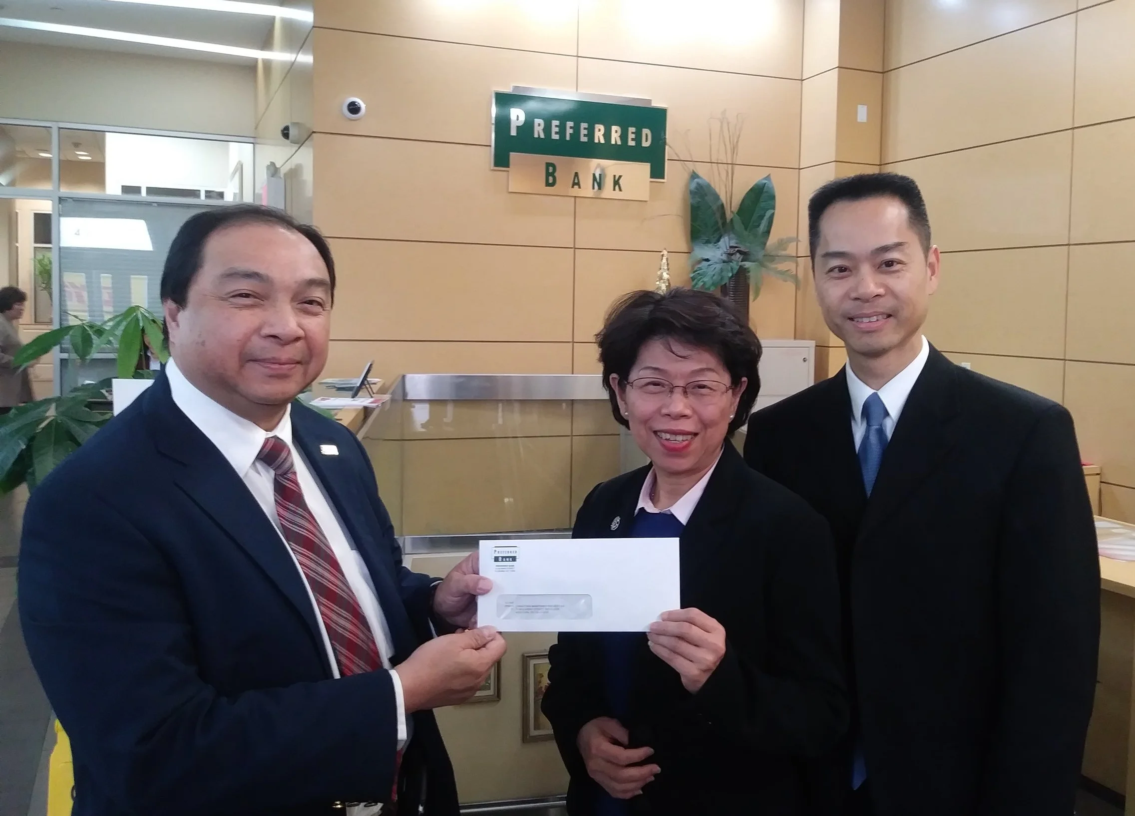 Preferred Bank Executive Vice President Ms. Kathy Yen (center) and Senior Vice President Mr. MK Chow (right) handing over the donation check to CMP Executive Director Mr. Hong Shing Lee (left)