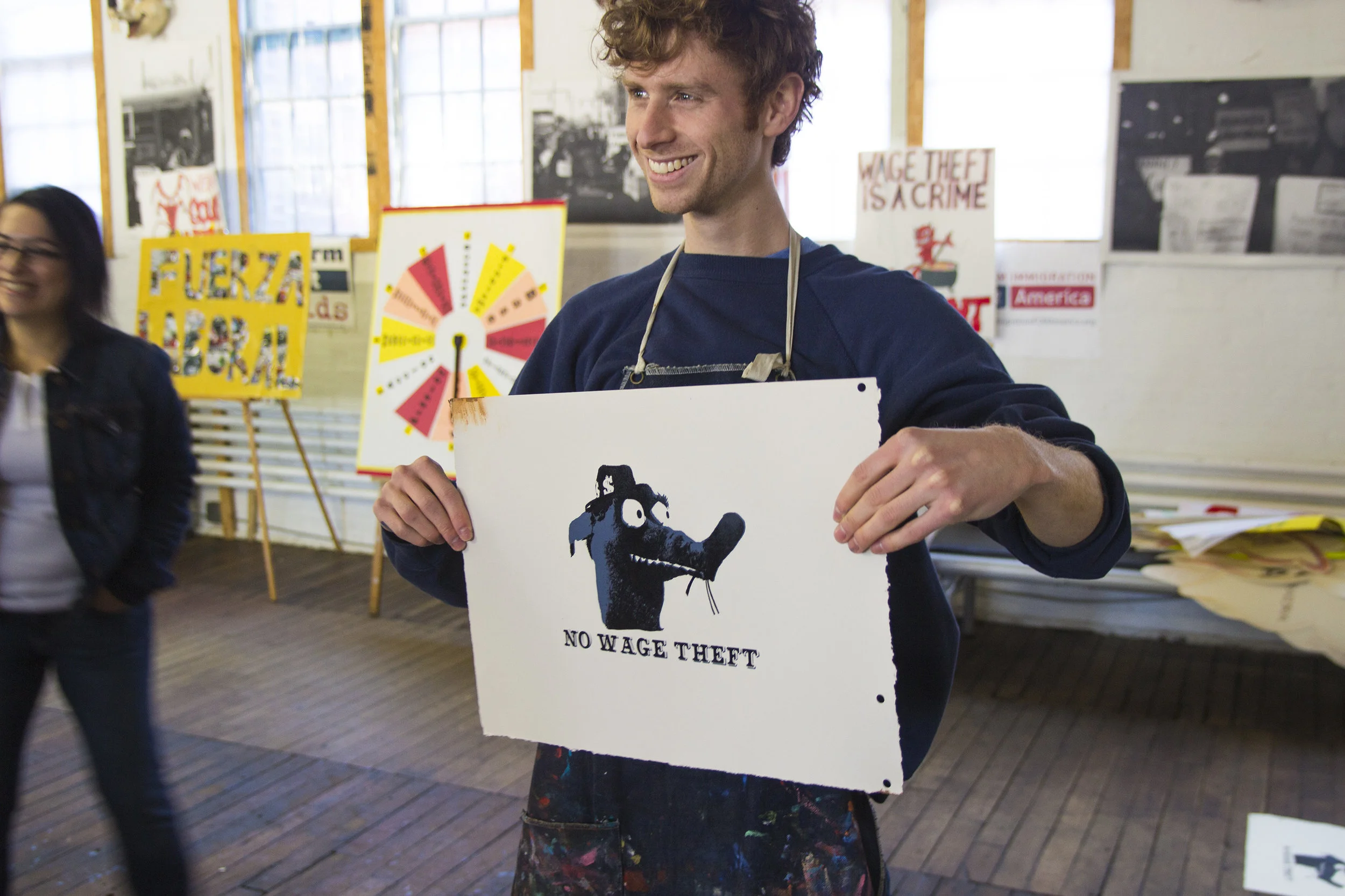 Participant with screenprinted protest poster 'No Wage Theft!'
