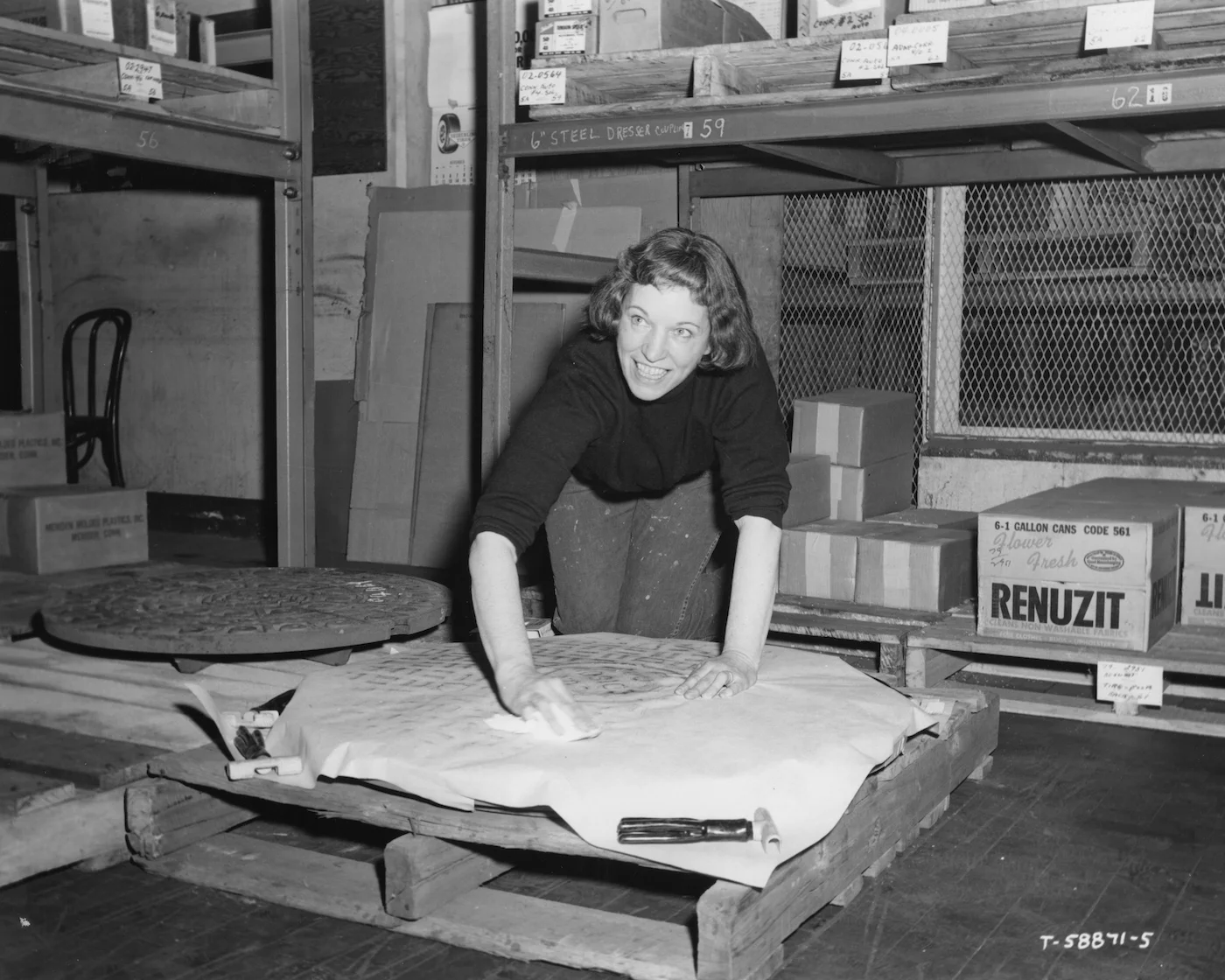 Dorothy Grebenak making a rubbing of a manhole cover, circa 1964