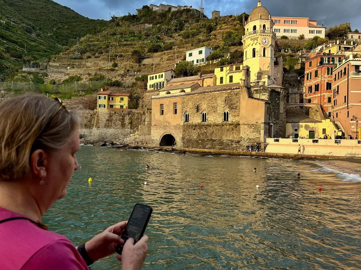 Sue&rsquo;s always checking on clients - even at sunset in Vernazza, Cinque Terre! #techtroubleshootanywhere