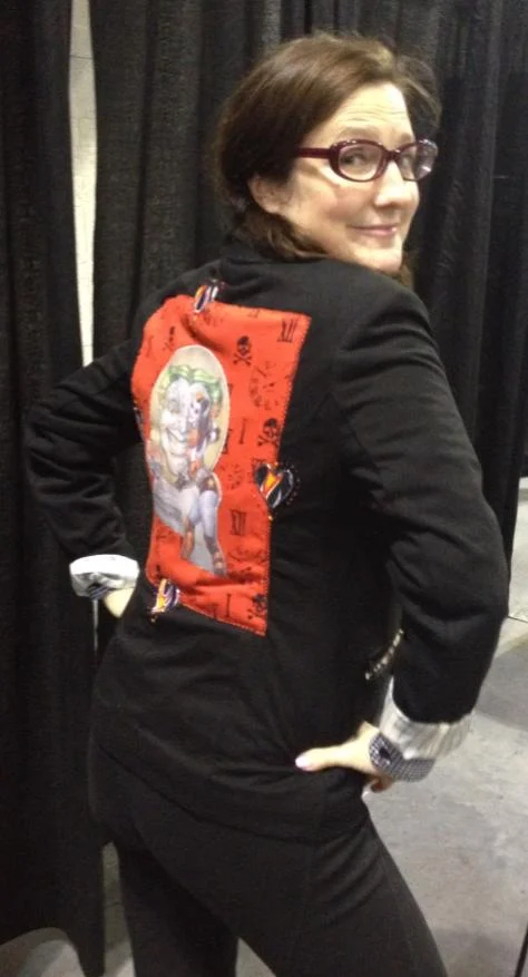 Comic book writer Amanda Connor wearing a blazer/jacket made by Mounts with Connor’s Harley Quinn from Issue #0 . Photo credit: Heroicouture
