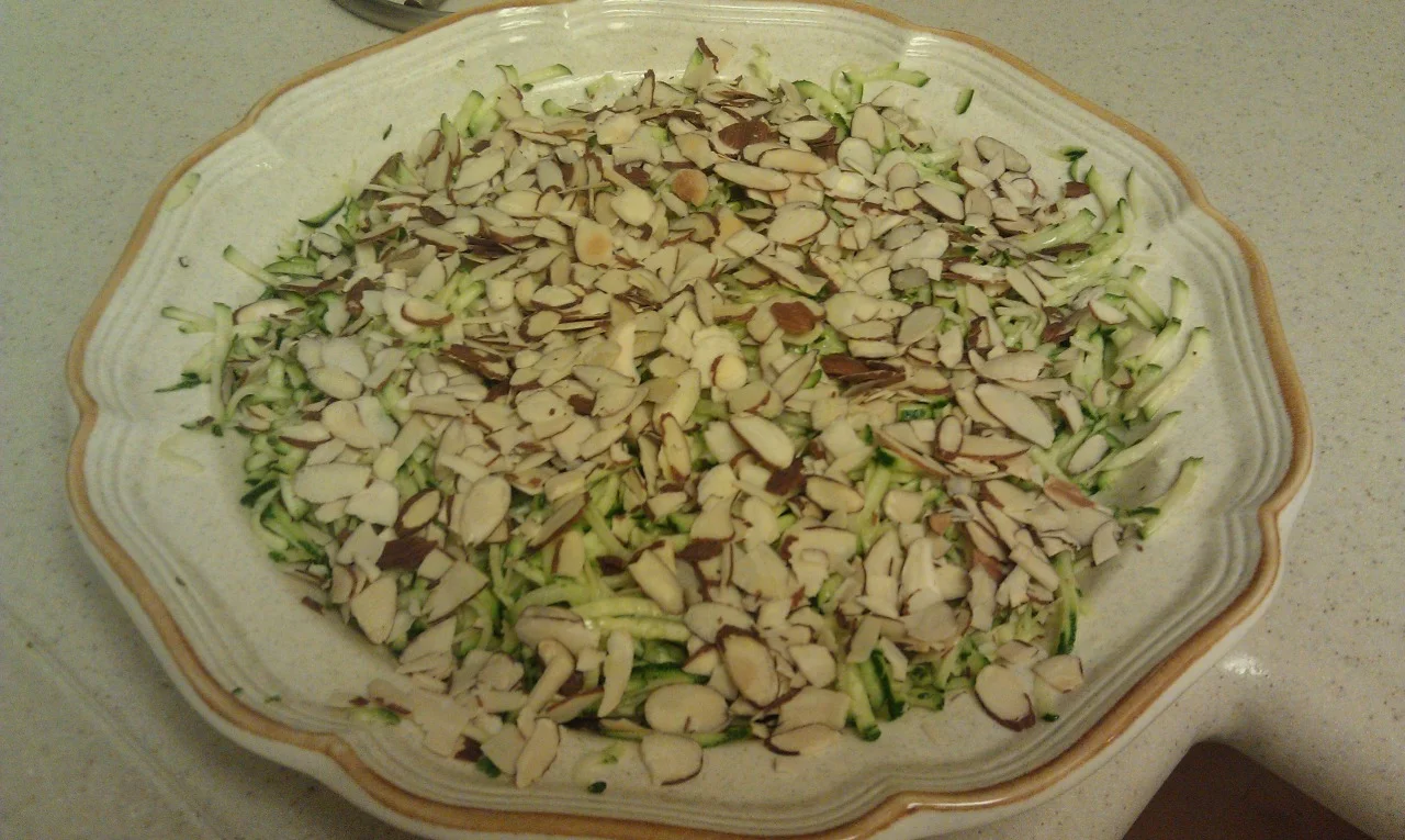 This is a very easy to make summer salad when the zucchini is at its best.
Grate a few zucchini squash or you can easily substitute another variety. Dress it with lemon juice and olive oil. 1 Tbsp of lemon juice to 3 Tbsp of olive oil. Toss and season with salt and pepper. You can add a little fresh lemon zest and fresh parsley as well. Spread on a plate. Toss toasted almond slices on the top.