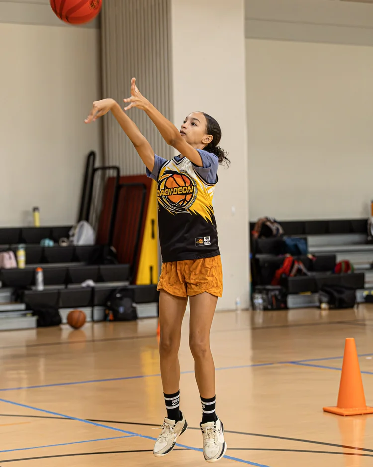 Youth basketball players developing skills during a Coach Deon Basketball camp