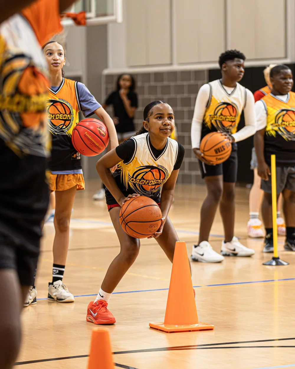 Young basketball players participating in structured Coach Deon Basketball camp instruction in The Woodlands