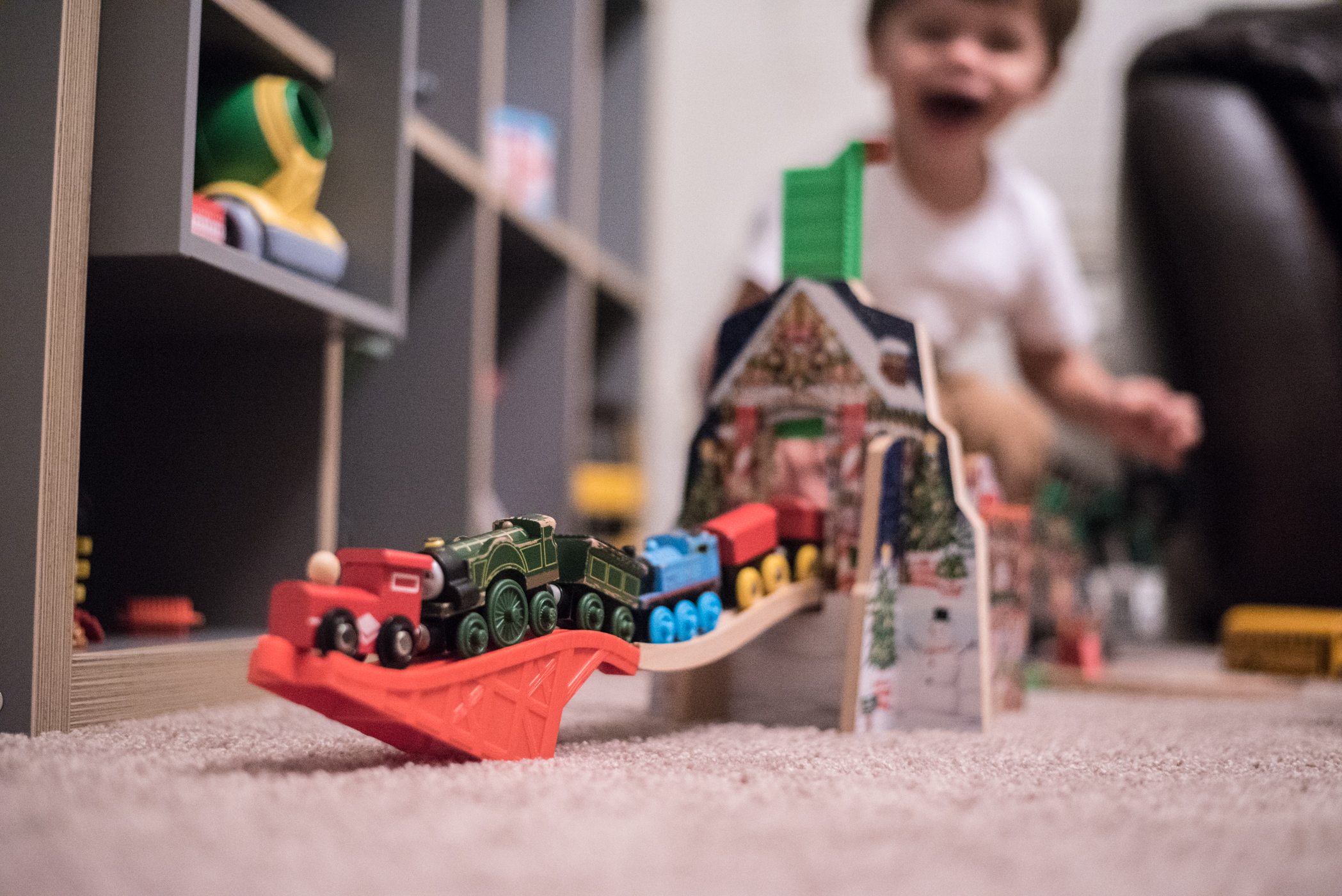 I intended to photograph how nicely he'd lined up his trains, but I love his expression in the background. He's so amused even after almost 2 years of playing with these same toys daily.