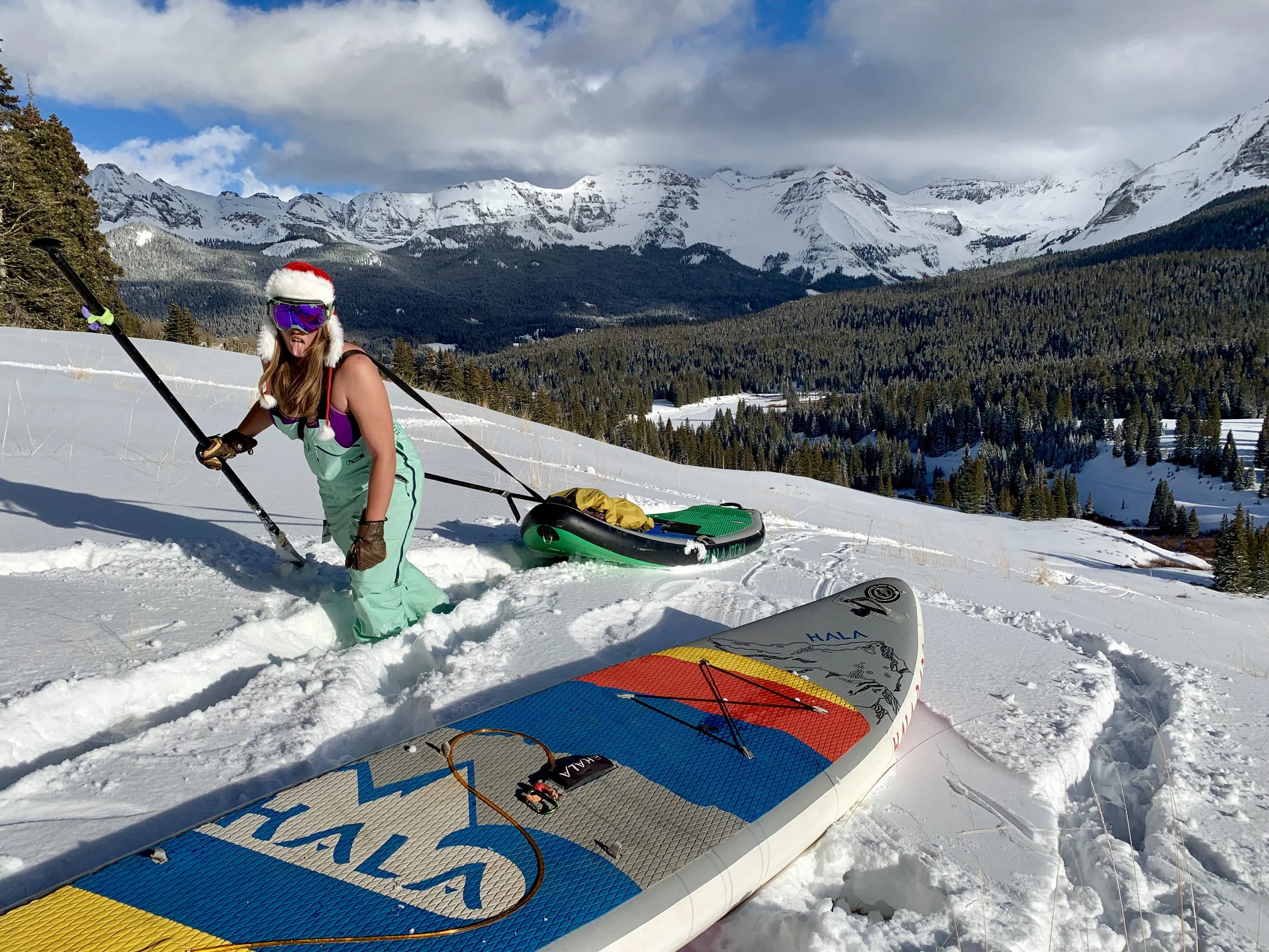 Hiking a stand up paddle board to the top of the hill on Lizard Head Pass in the San Juan Mountains near Telluride Colorado