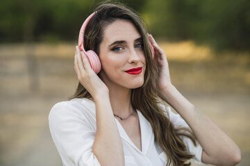 portrait-spanish-woman-white-shirt-listening-music-with-pink-headphones-park_181624-56561.jpg