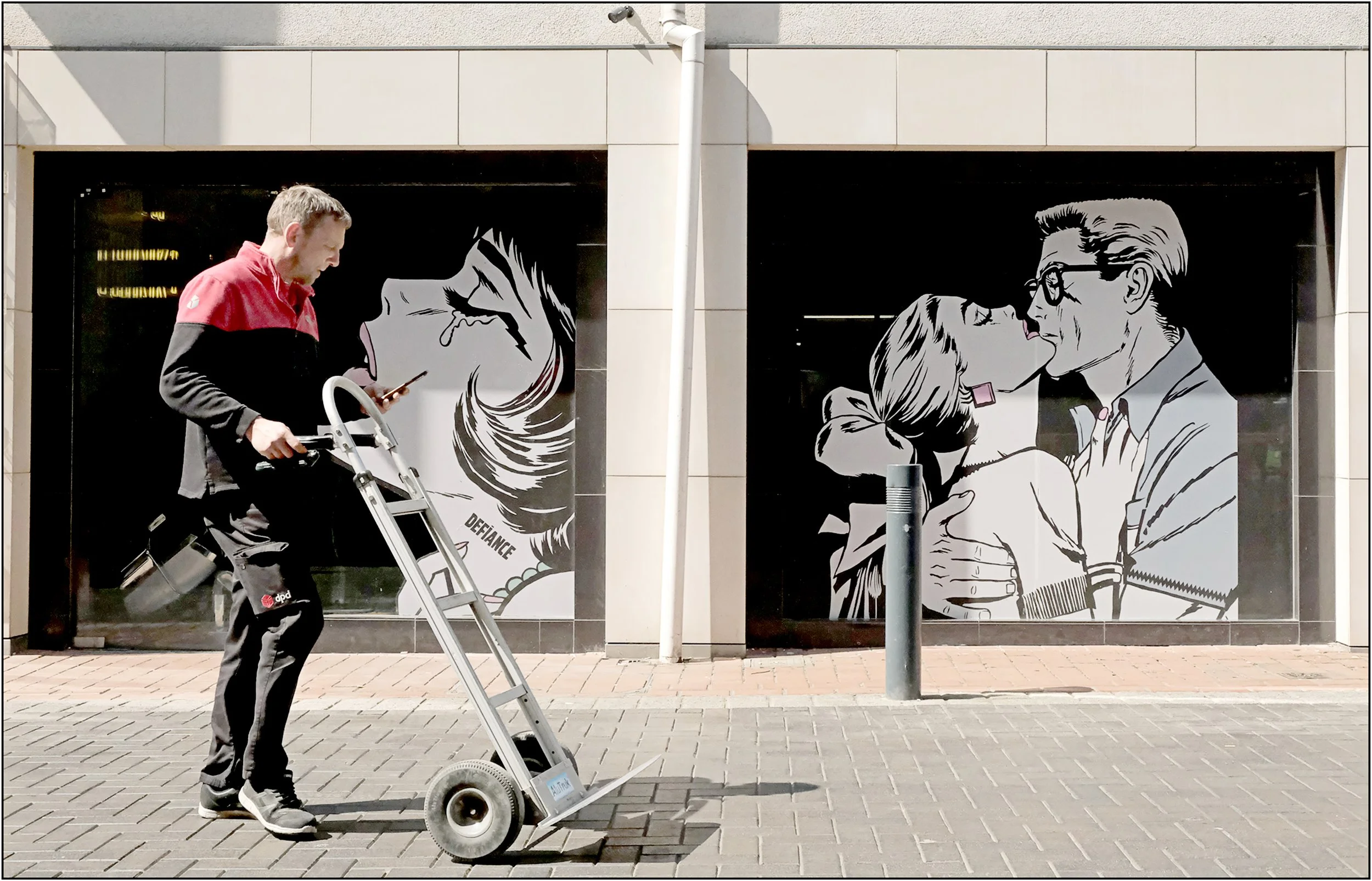 Len Downes - The Kiss - This location in Leeds had two pieces of artwork crying out for a passing figure. Waiting for ten minutes, a suitable person appeared, unaware of my presence, and the shutter was pressed at the moment he appreared to be going 