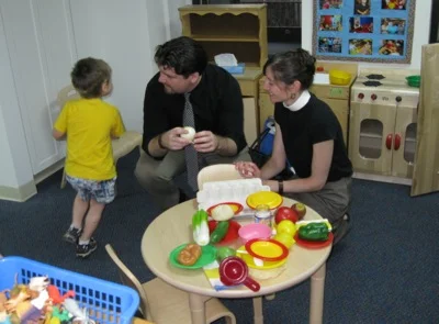 Prof. Joshua Davis and his wife, Chaplain Danielle Thompson, play with their son after the blessing.