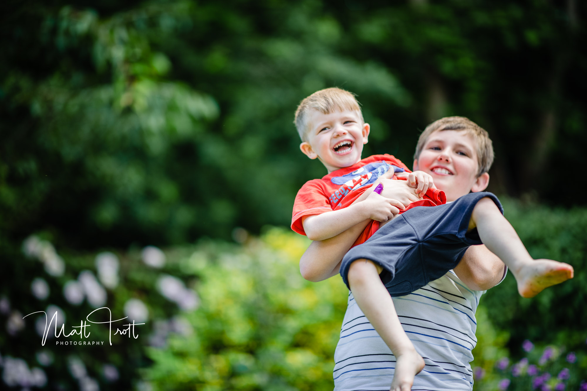 boy laughing and being lifted up by his cousin