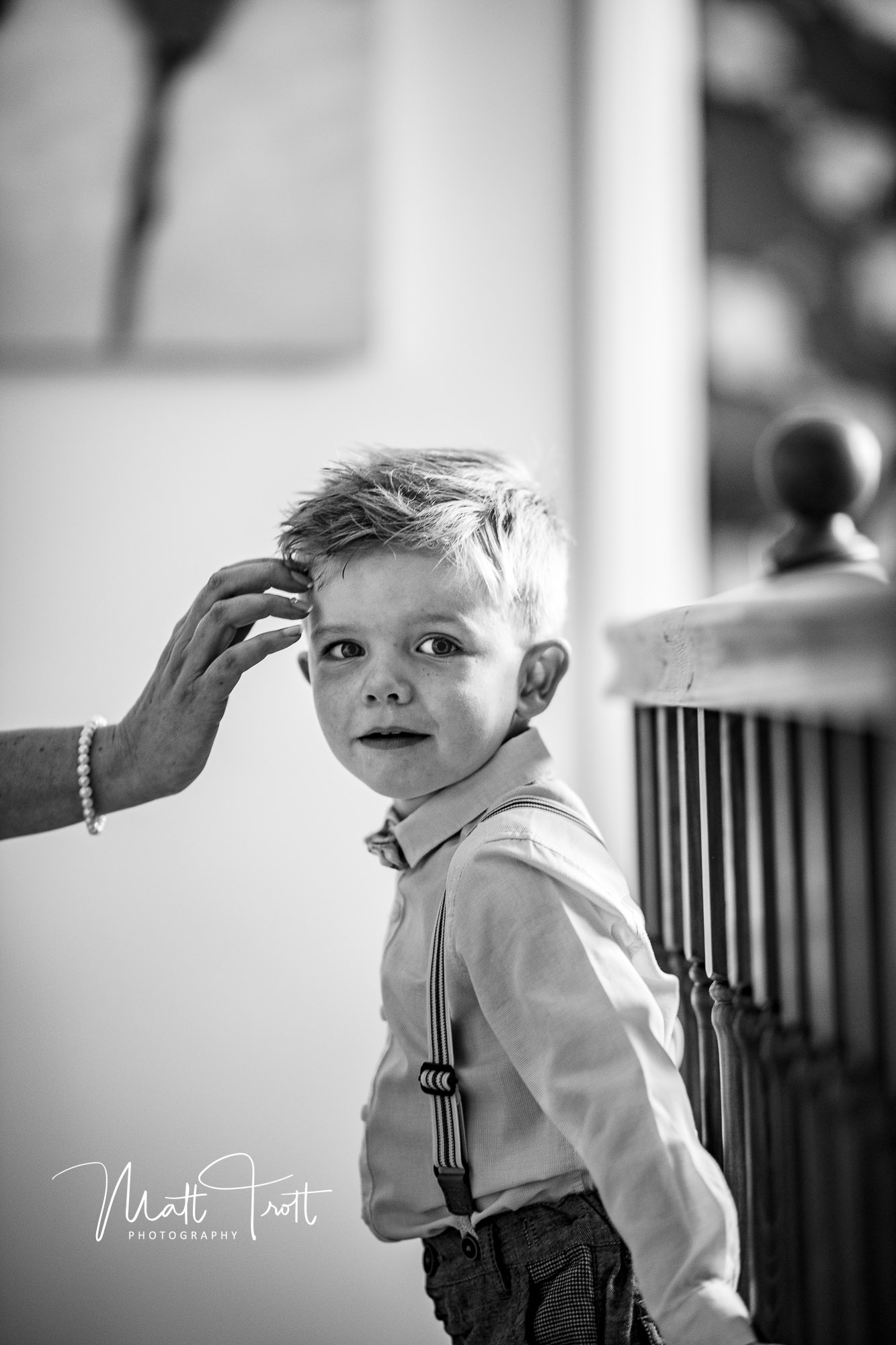 Young boy having his hair gelled by Mum on the morning of the wedding.