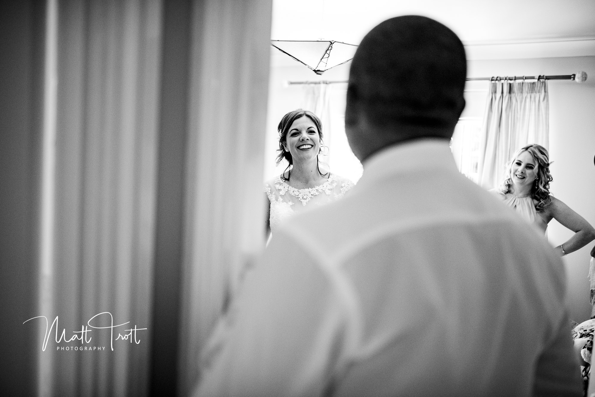 Bride smiling at her brother as he sees her in her wedding dress for the first time.