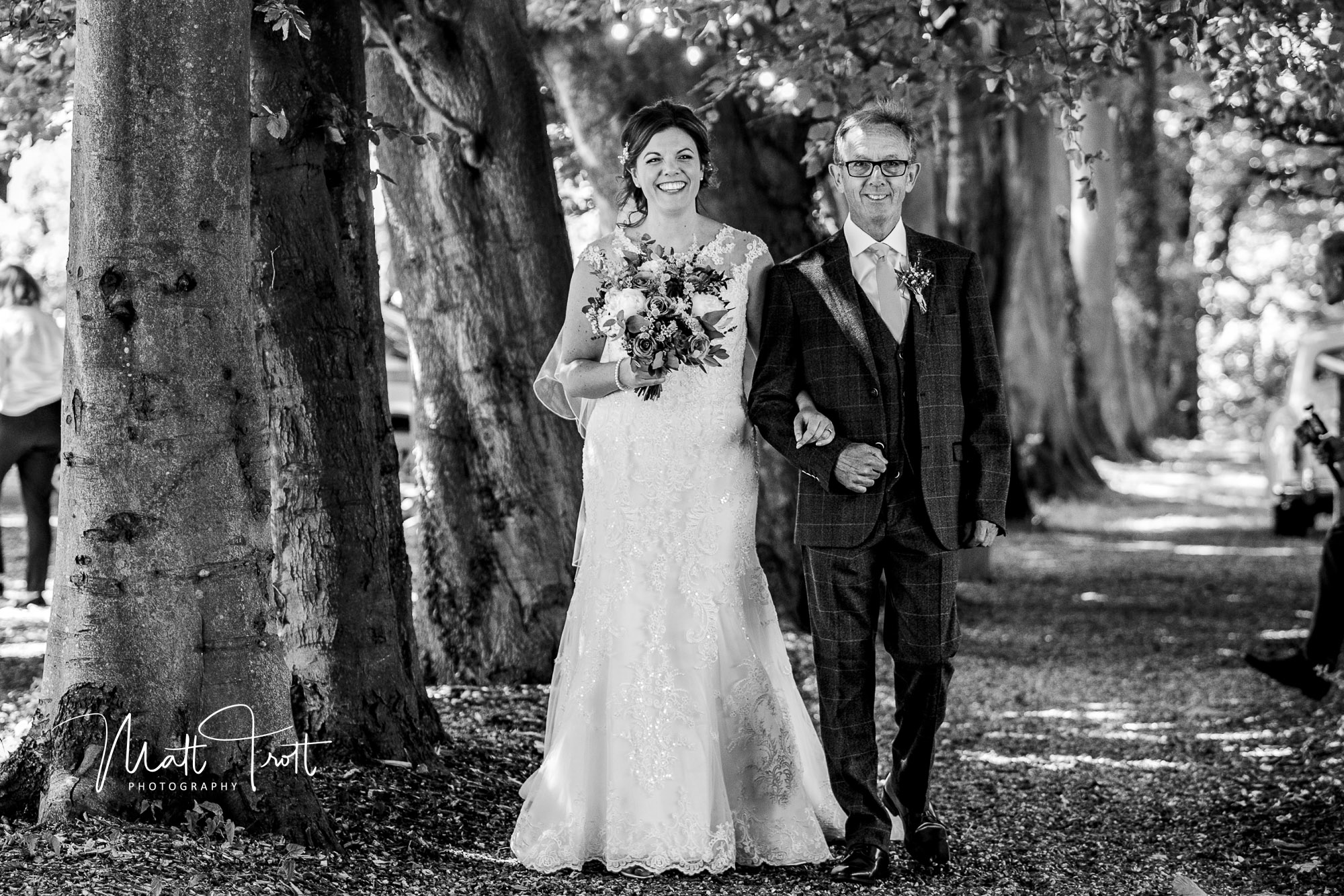 father of the bride and bride walking down the aisle at their outdoors wedding