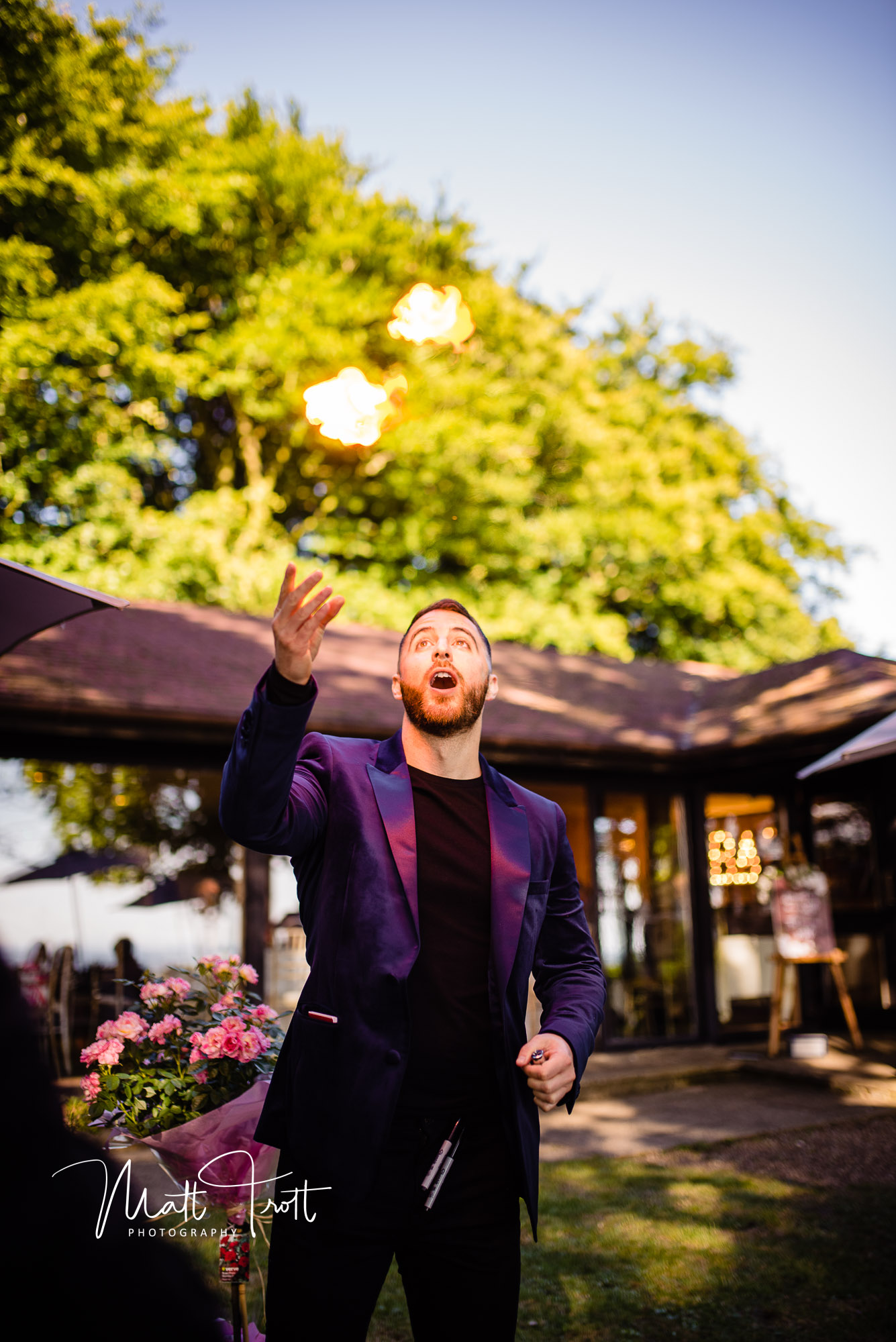 Magician throwing fire into the air at crown lodge kent during a wedding