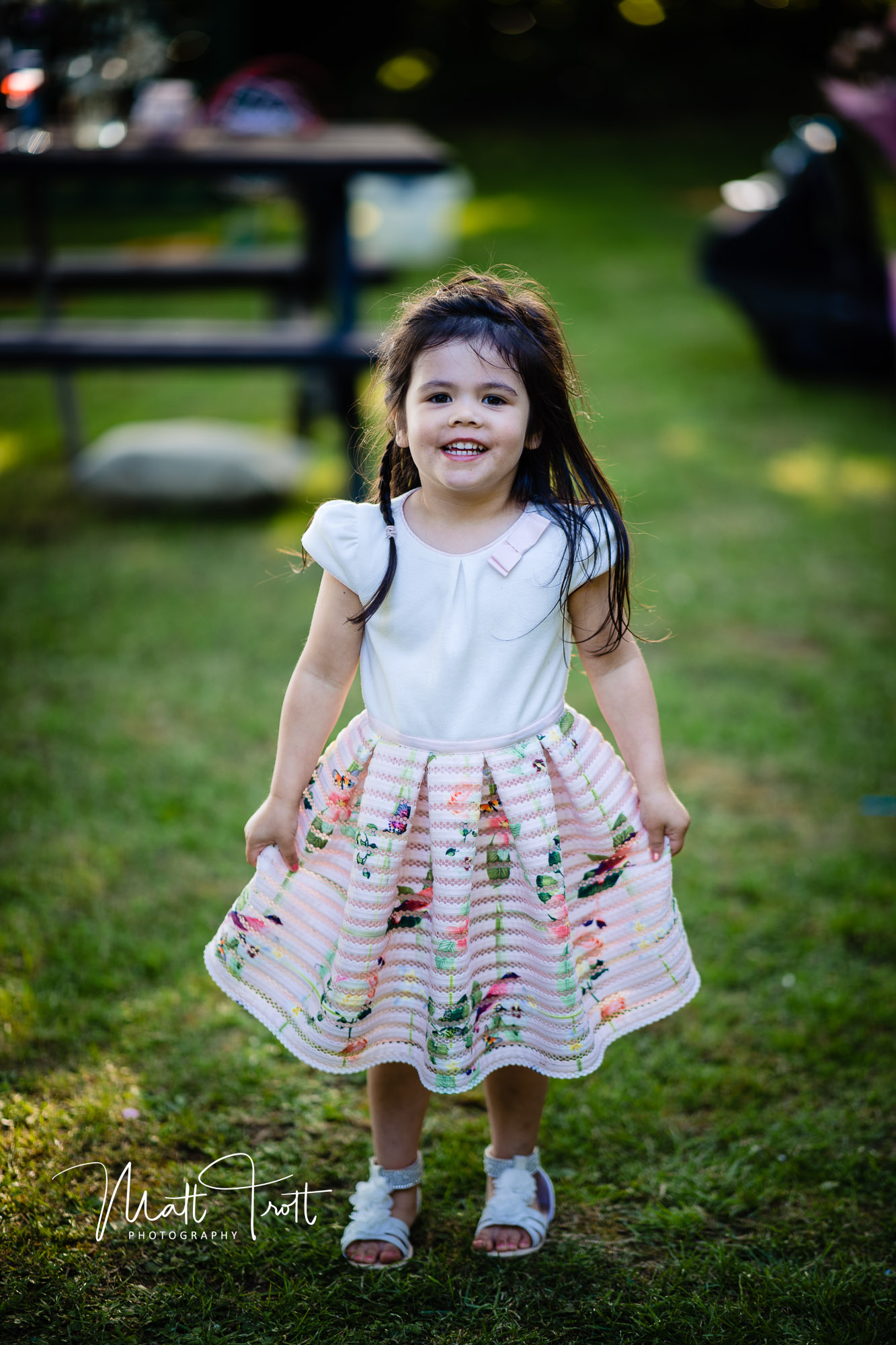 Cute little girl smiling at the camera in a frilly dress