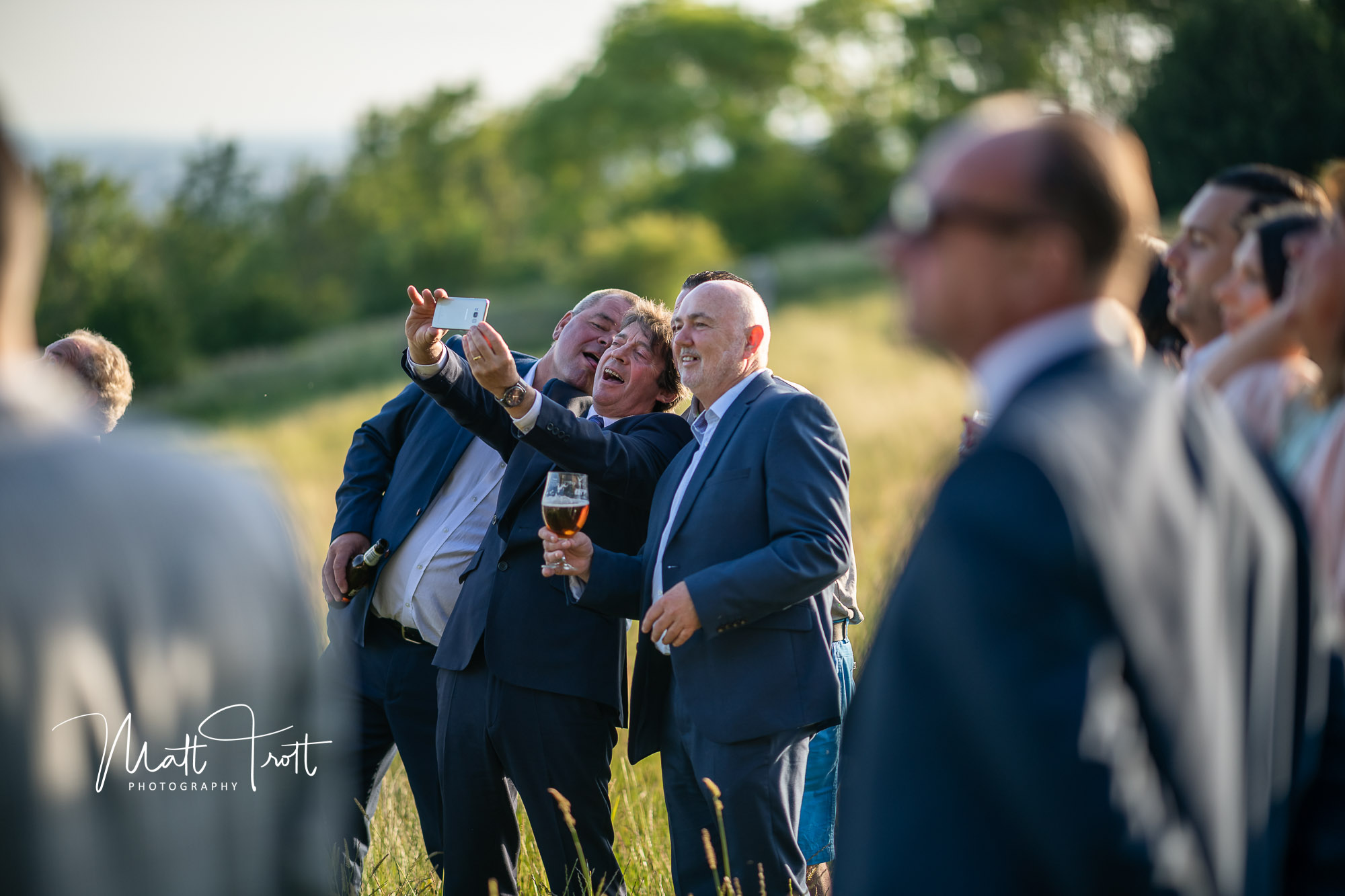 Guys taking a funny selfie at a wedding