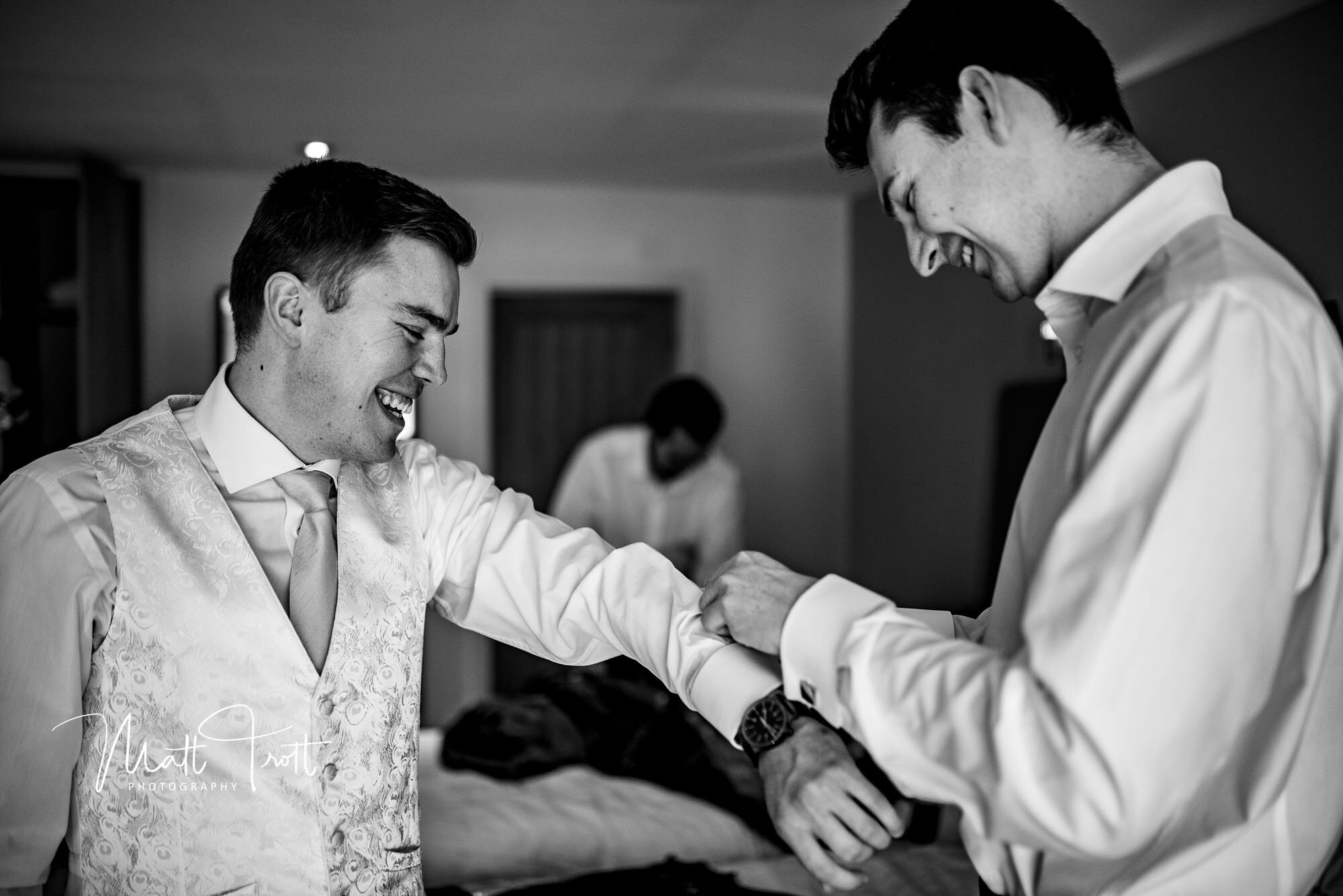 Groom prep - adding cufflinks at a wedding in Essex