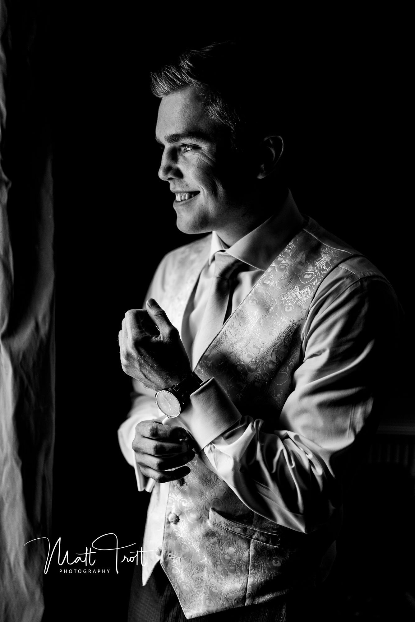 black and white groom picture in front of the window at a wedding in Kent