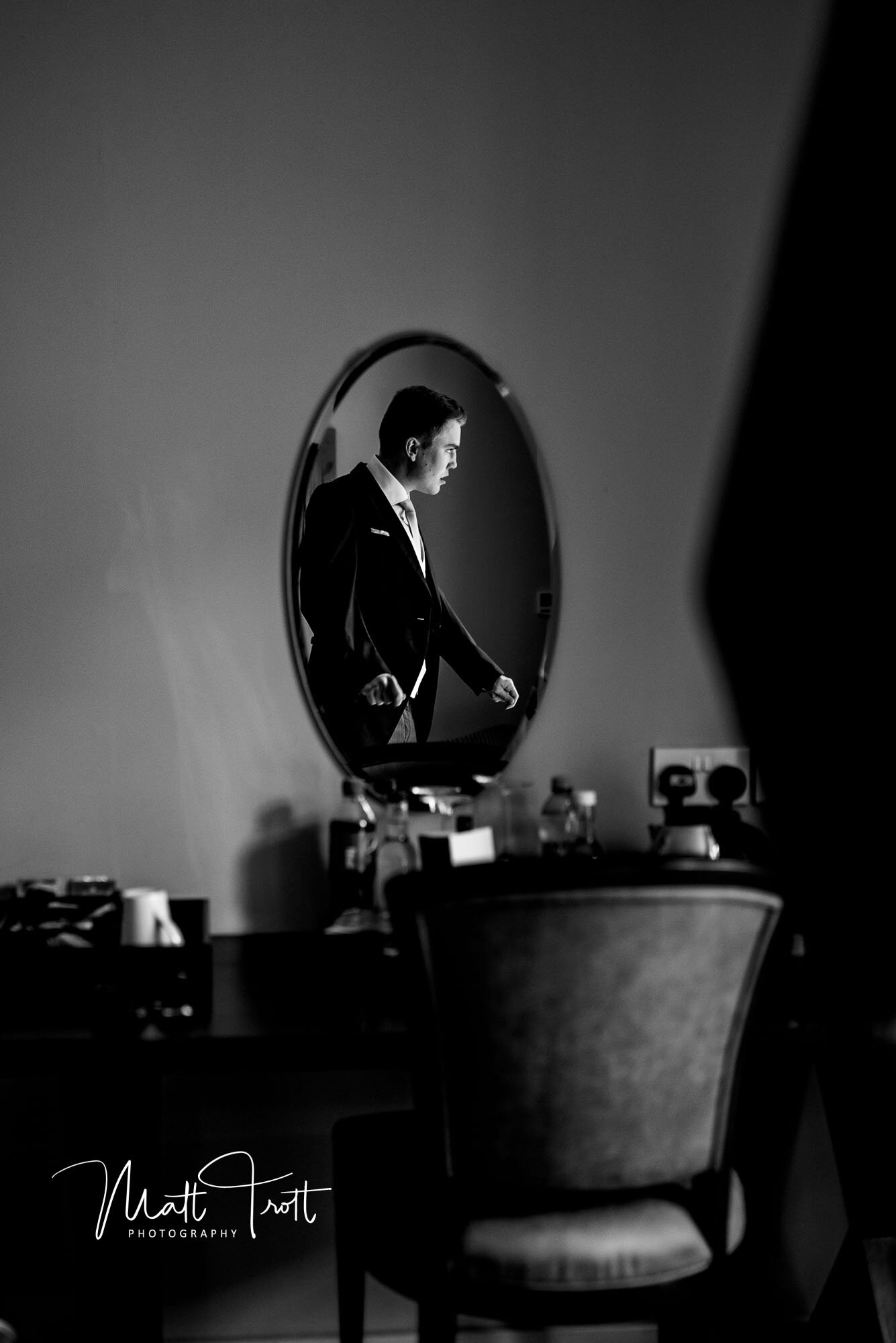 Groom getting ready in the mirror