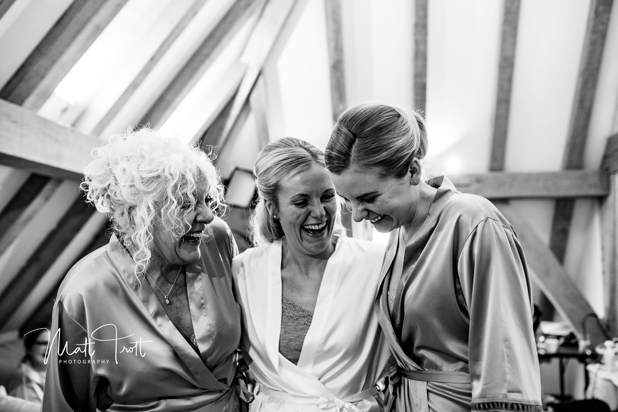 Bride and Bridesmaids laughing at the old Kent Barn in Robes