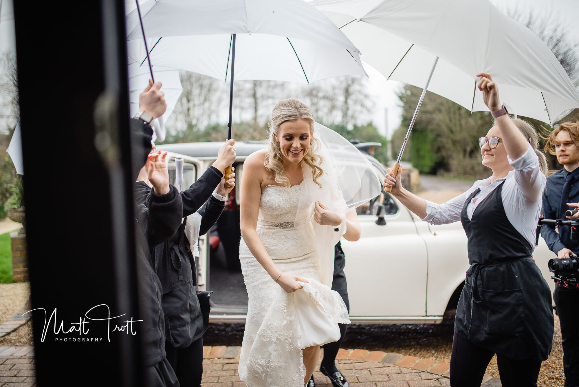 Bride arriving in the rain at the Old kent barn