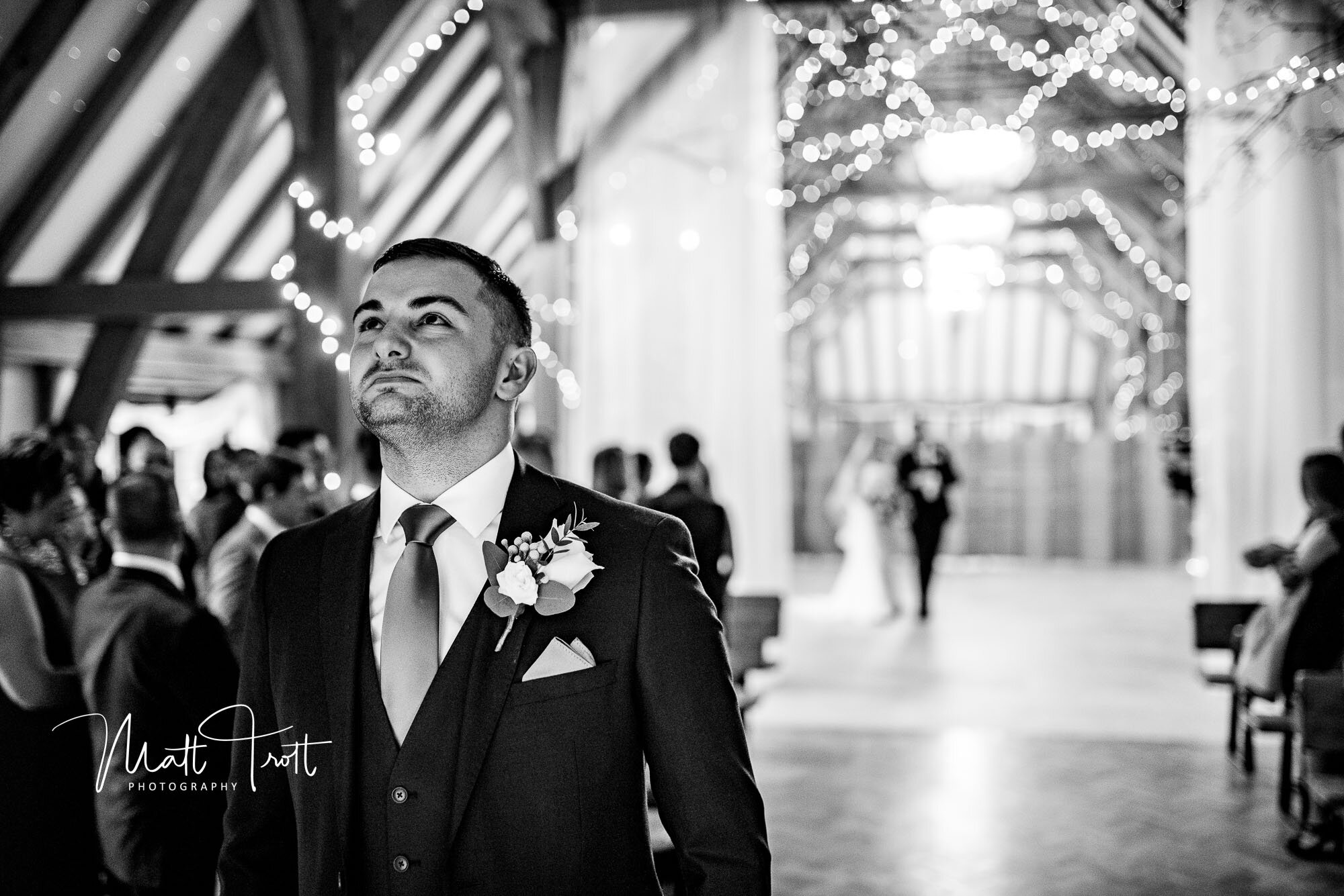 Emotional groom waiting for bride to walk down the aisle at the old kent barn