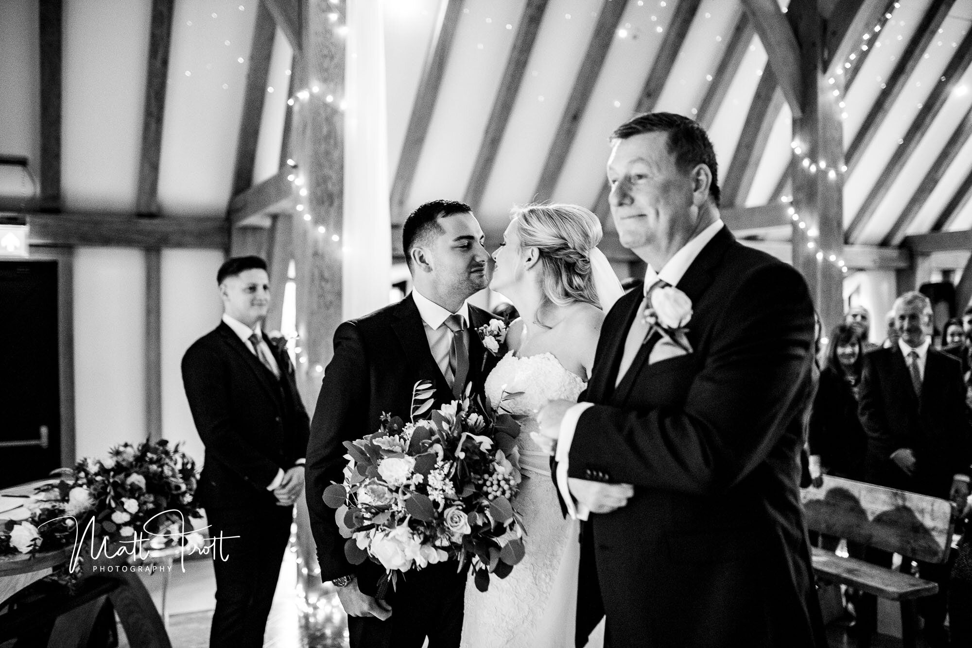 Groom and bride kiss at the old kent barn