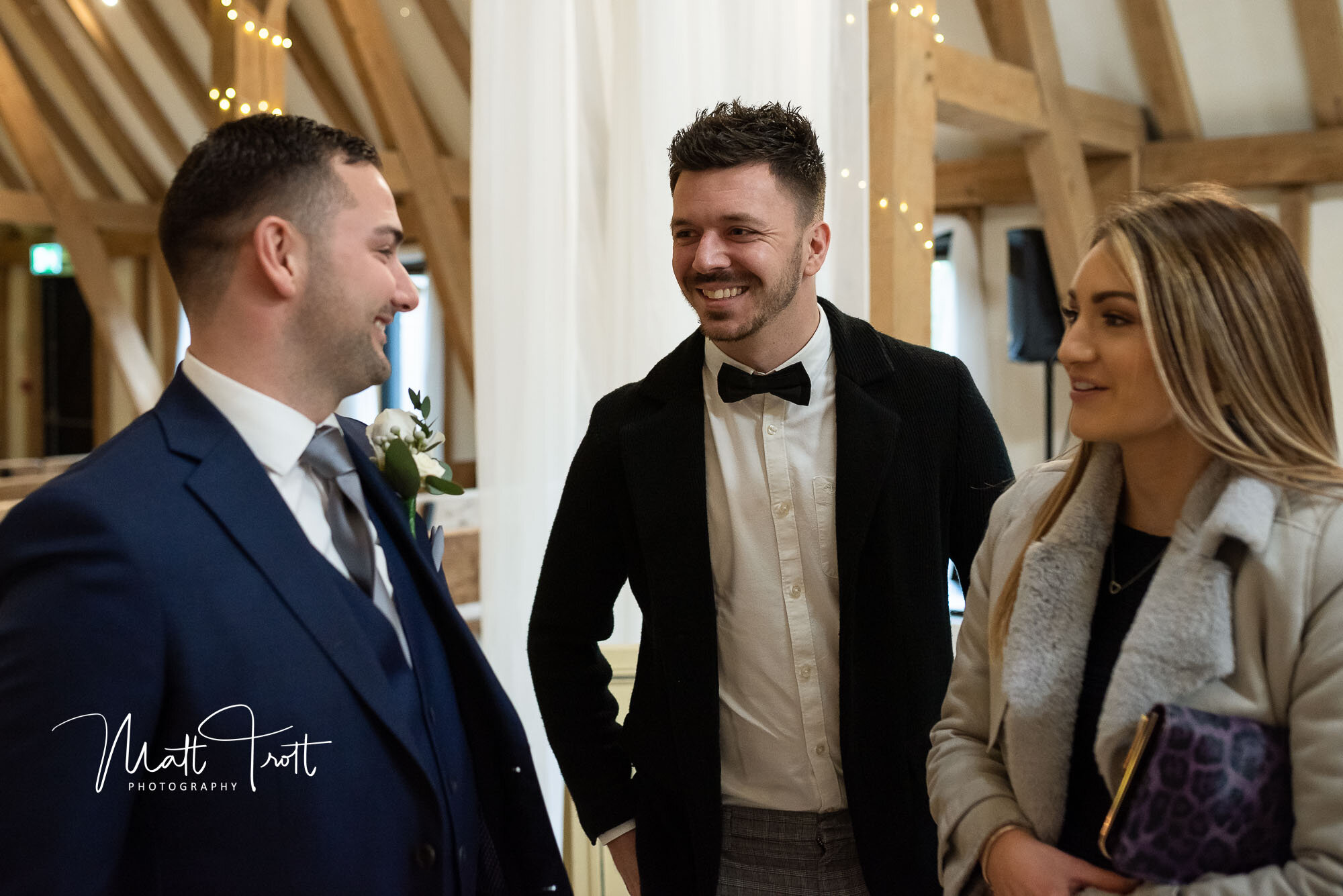 Guests chatting to the groom at the old kent barn