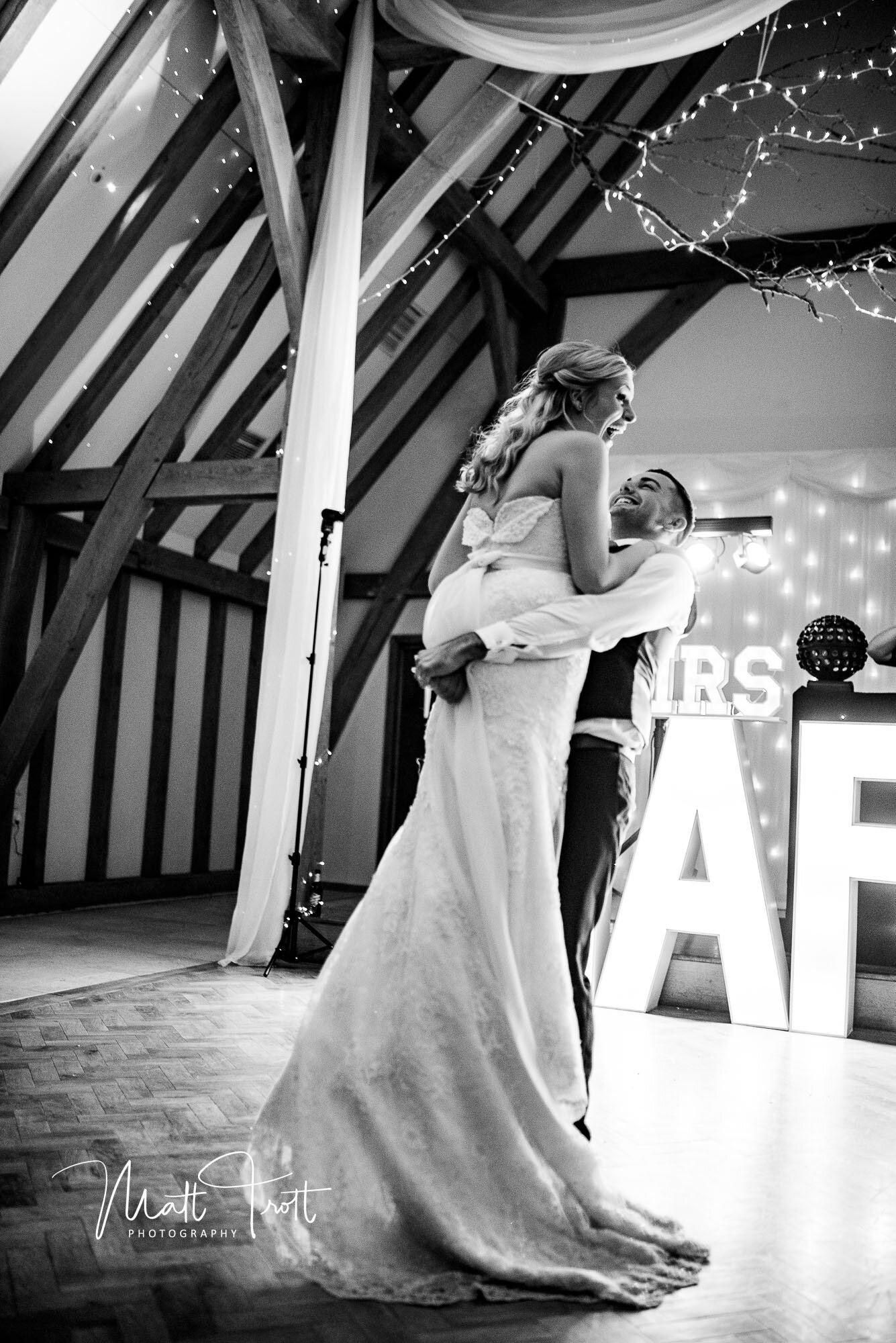 Groom lifting bride during the first dance at the old kent barn