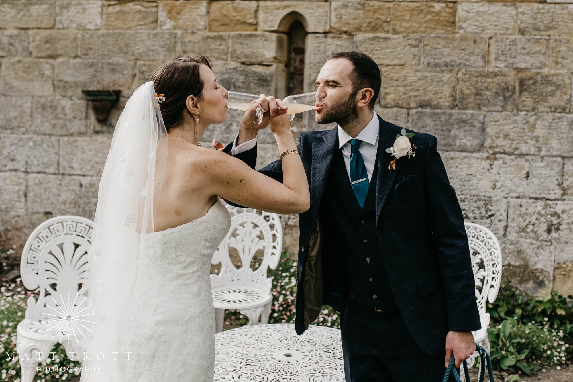 bride and groom drinking champagne at chiddingstone castle