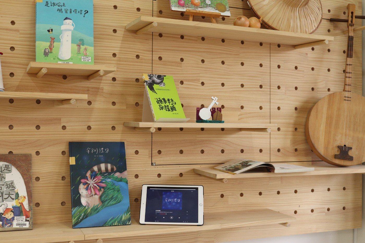 木頭洞洞板展示牆，可依據書籍內容，用視覺、聽覺、觸覺等展示每月主題書籍。
