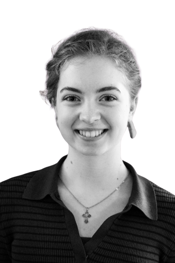 Black and white portrait of a smiling woman with long dark hair, wearing a necklace.