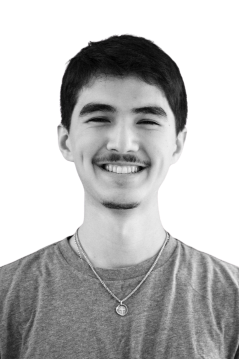 Black and white portrait of a smiling man with glasses, beard, and mustache, wearing a checkered shirt.