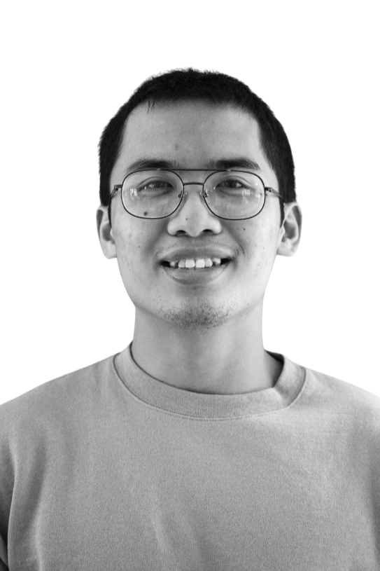 A smiling young woman with long hair and earrings, looking directly at the camera in black and white.