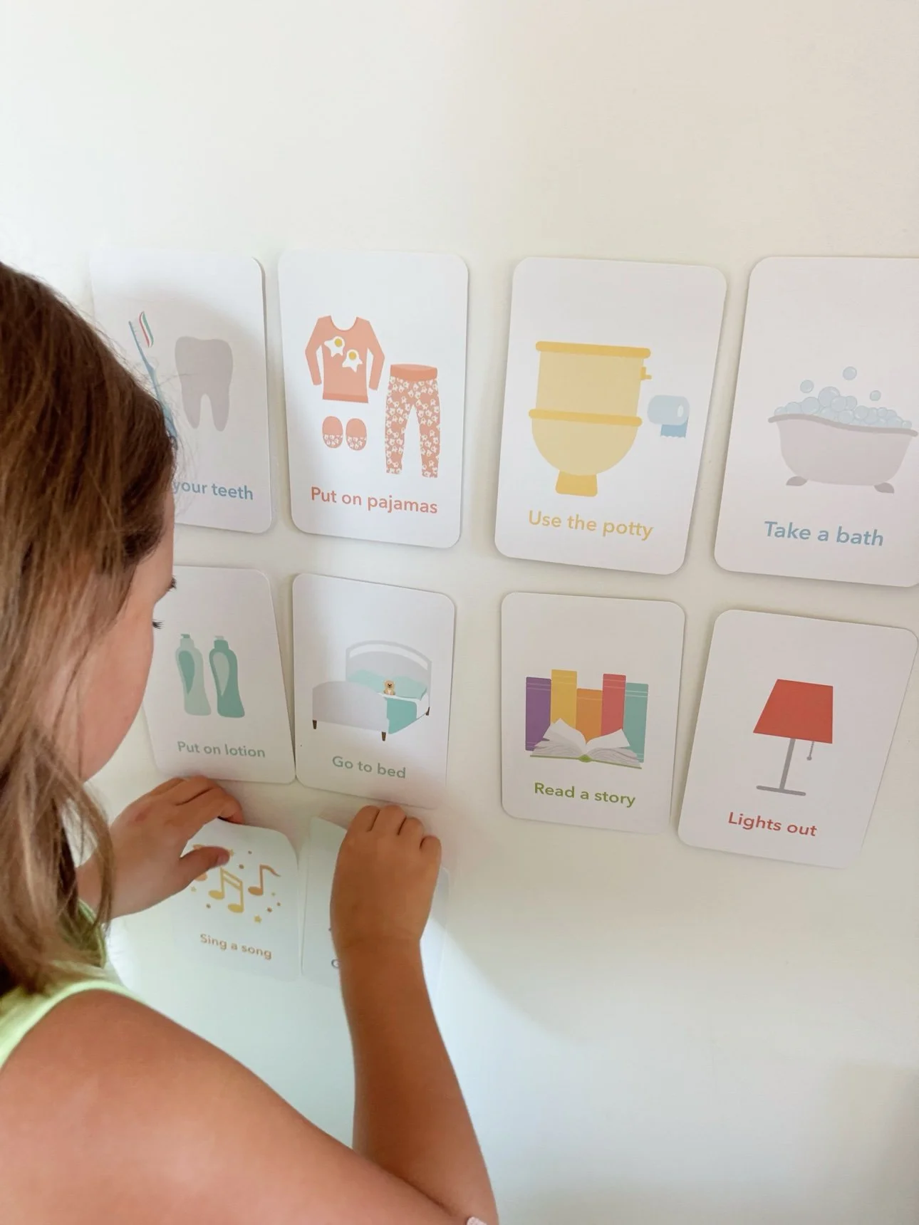 Toddler's bedroom wall with routine cards stuck on using Velcro dots — visual schedule for toddlers