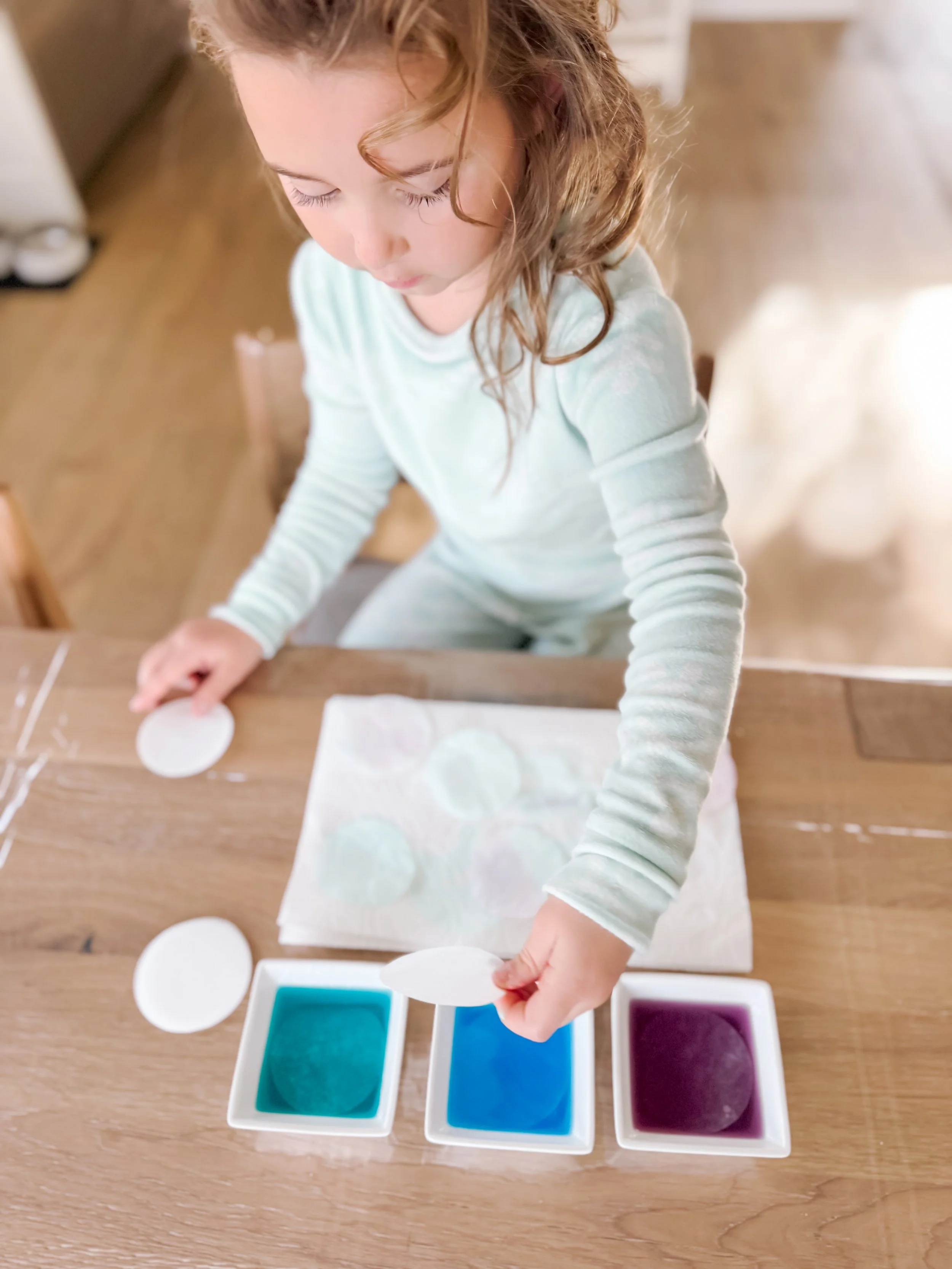  Toddler coloring coffee filters with food coloring and water using dipping, dripping, and spraying techniques for DIY sensory flower craft 