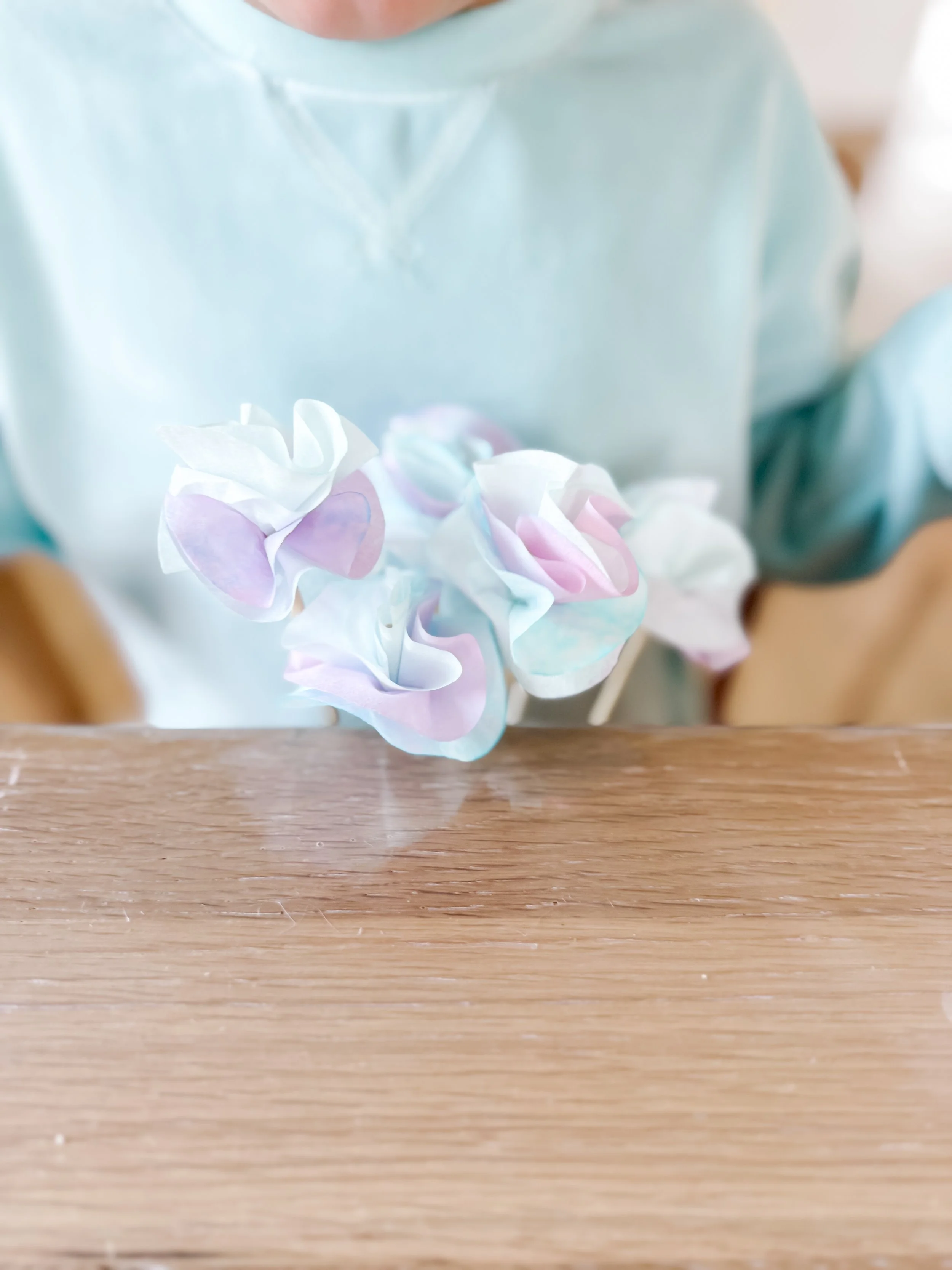  Toddler observing and arranging colorful coffee filter paper flowers, exploring color mixing, fine motor skills, and hands-on learning 