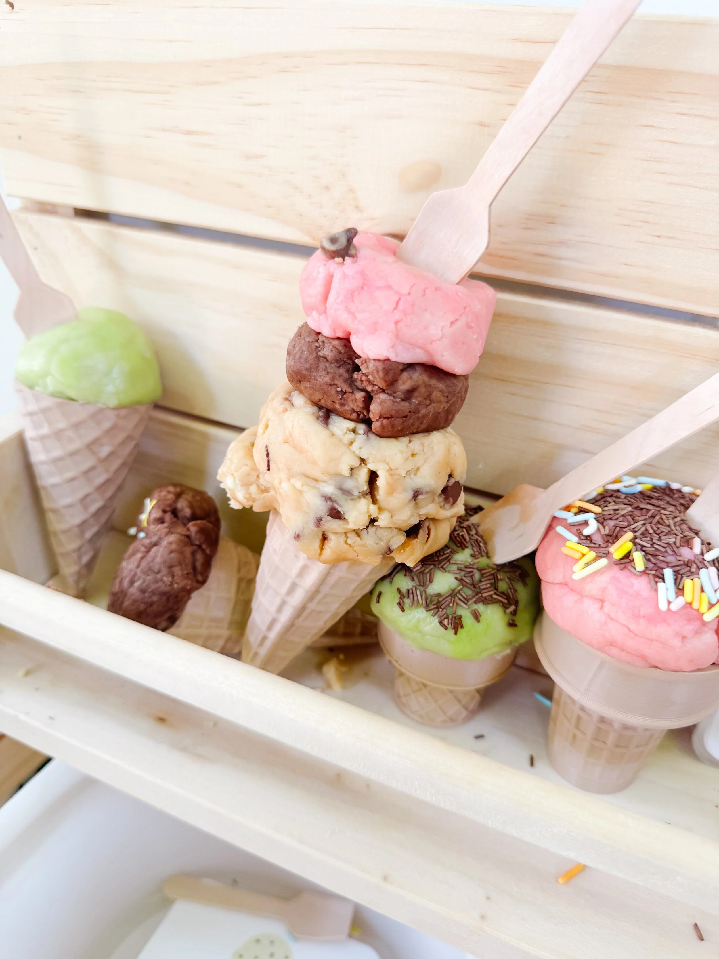 Tall pretend ice cream cone made with scoopable play dough in an ice cream mud kitchen.
